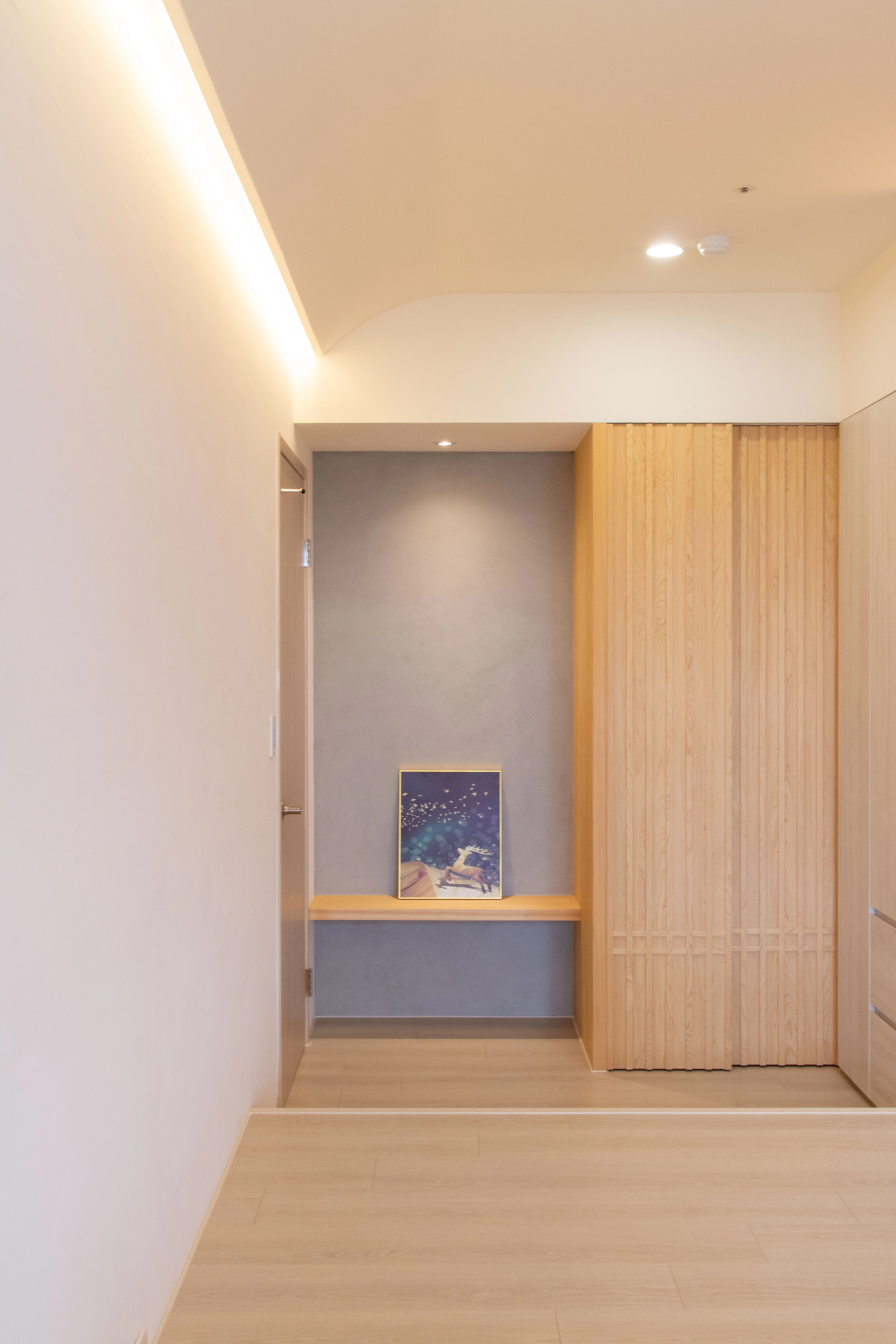 淺色木質營造溫馨感。木作格柵造型門片與隱藏門，讓空間動線更流暢。