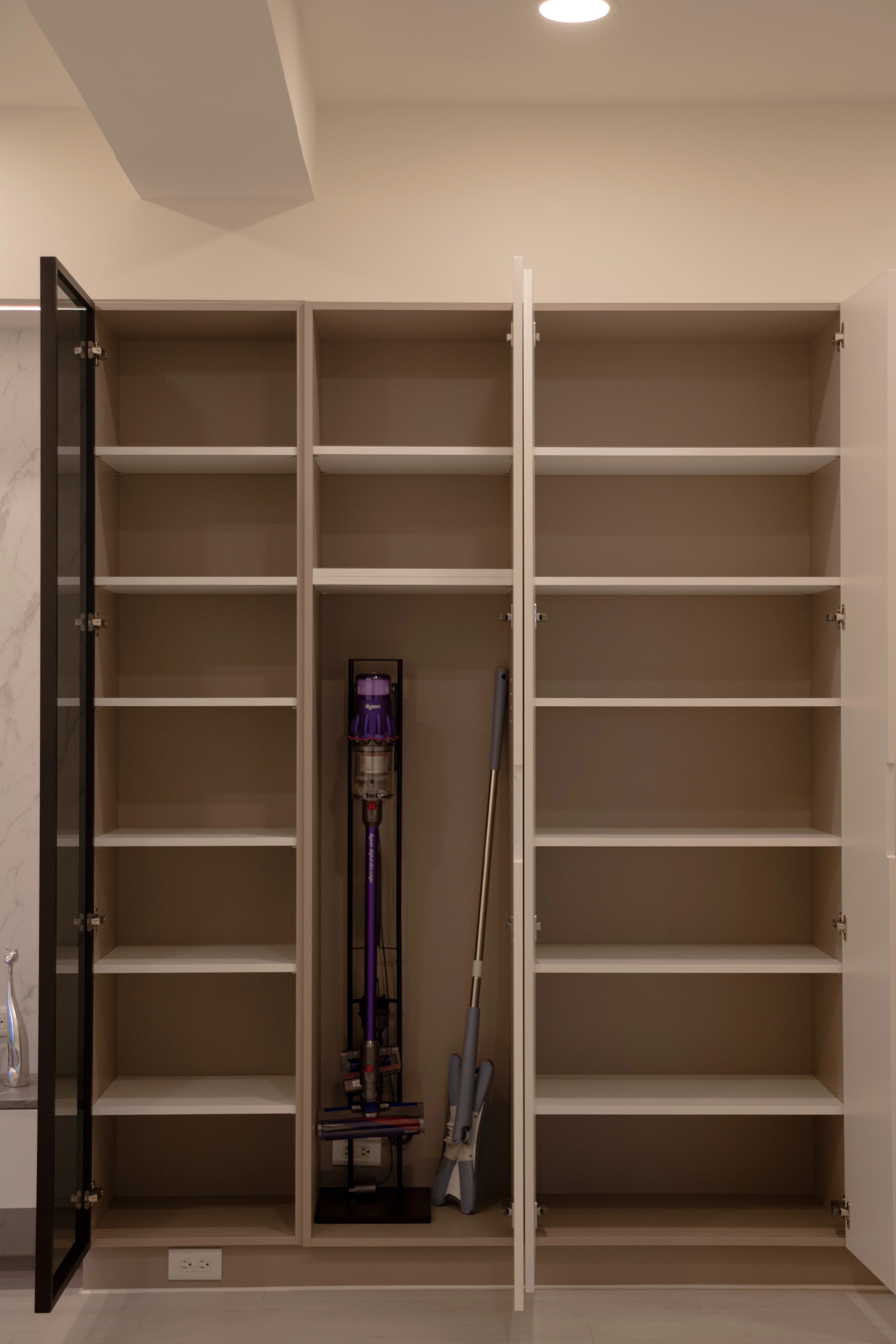 奶茶色系系統櫃內部照。多層板設計，搭配開放式層架與玻璃門片，展示與收納兼具。