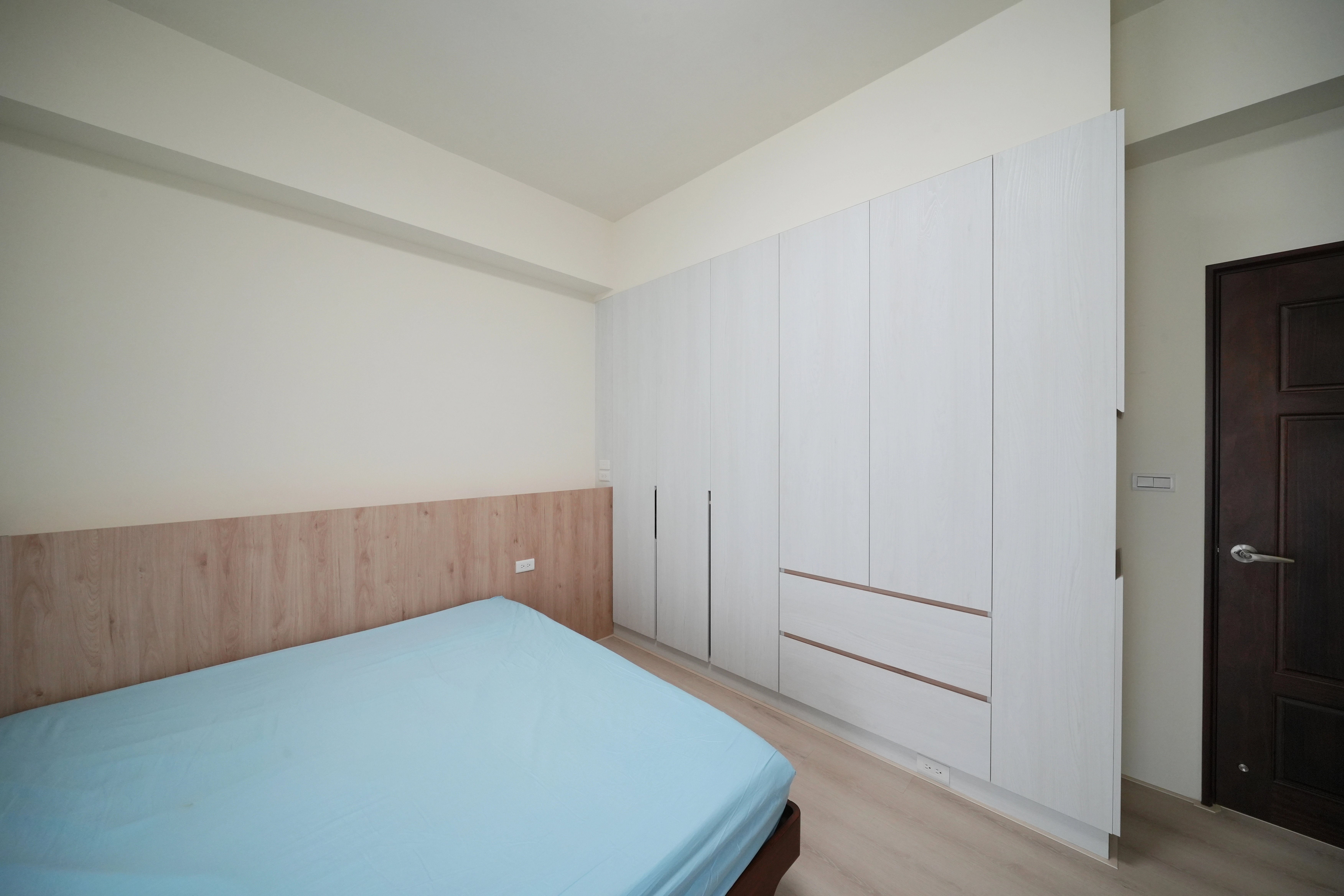 主臥暖木床頭背牆，超耐磨木地板。整面開門衣櫃，轉向櫃極大化儲物機能。