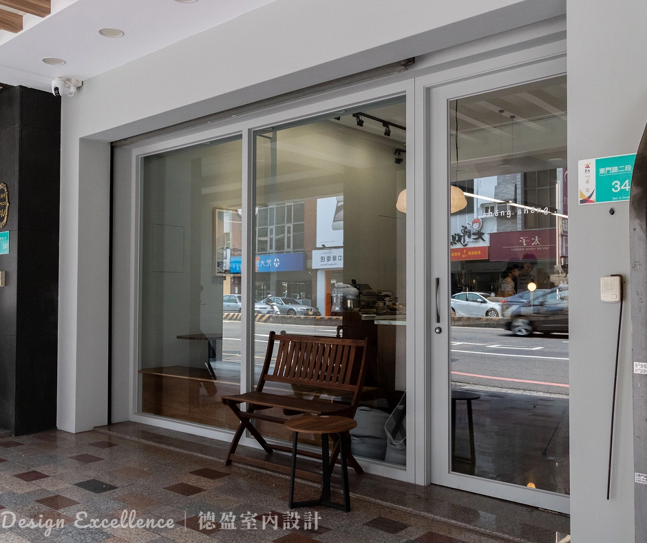 咖啡廳入口木作雙面牆與強化玻璃設計，引入台南明亮日光。